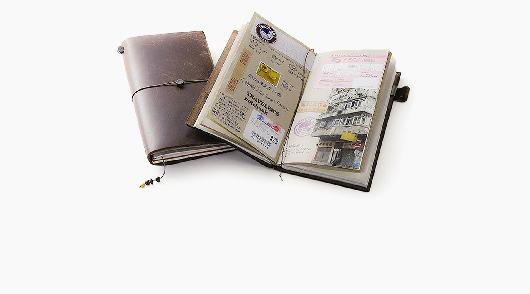 Aged and worn brown leather Travelers Co notebook from Japanese stationery brand Midori with notebook open showing details of a travel journal