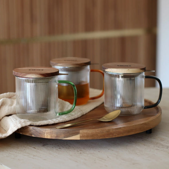 Tea for one in a borosilicate glass teapot mug with graphite grey handle, by French brand Ogo Living. Topped with a wooden lid to keep your tea warm while it brews.