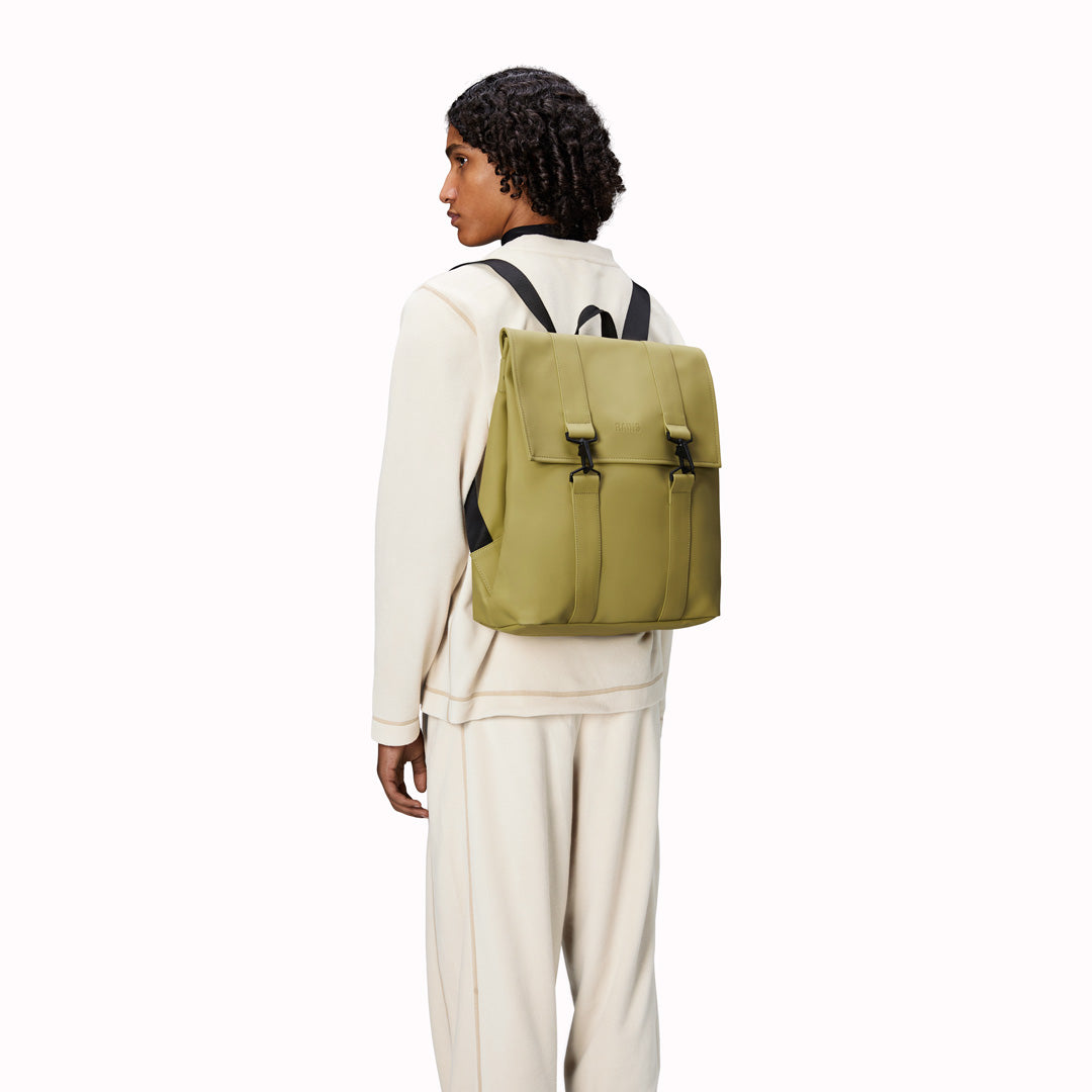 As Worn - Rains' MSN Bag W3 is their interpretation of the classic school backpack, reimagined for commuters. A minimal silhouette with dual strap and carabiner closure. Made from Rains’ signature waterproof fabric, with an internal laptop pocket and a roomy main compartment.