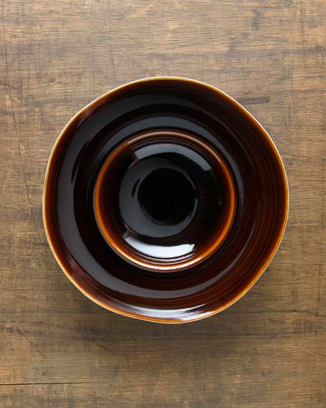 A rich brown glazed Japanese Mino ware bowl with a wide rim and hollowed out centre - suitable for serving pasta, starter dishes or soup.