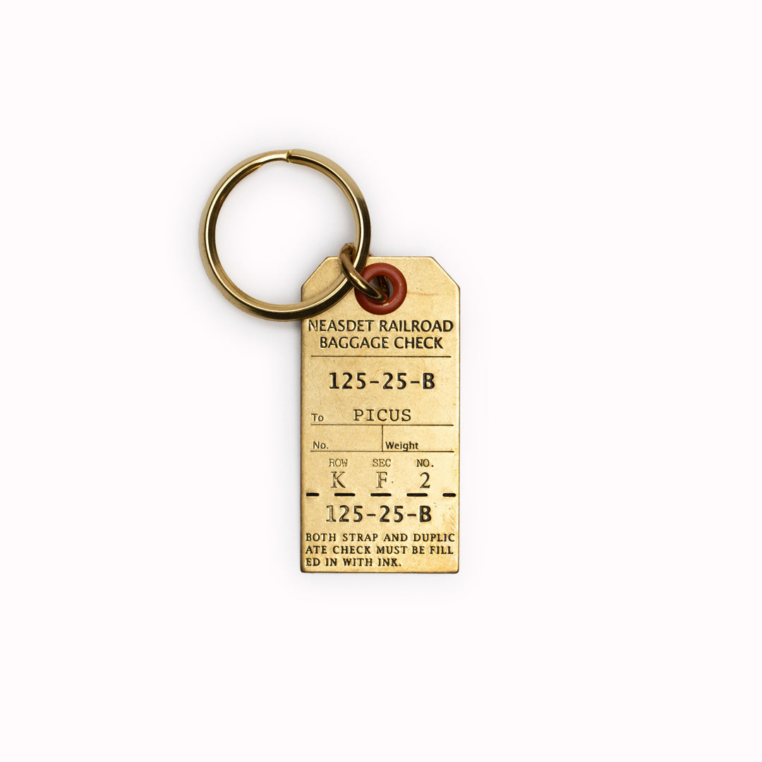 Crafted in Japan from high-quality stamped brass, this luggage tag keyring boasts dimensions of W. 23mm x H. 45mm.