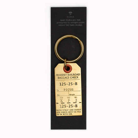 Crafted in Japan from high-quality stamped brass, this luggage tag keyring boasts dimensions of W. 23mm x H. 45mm.