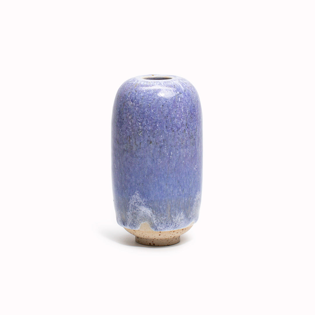 The Lavender blue design is hand-thrown in watertight stoneware. Due to the rounded taper at the top of the vase, the glaze melts down the sides of the cylindrical vase mimicking melting ice.