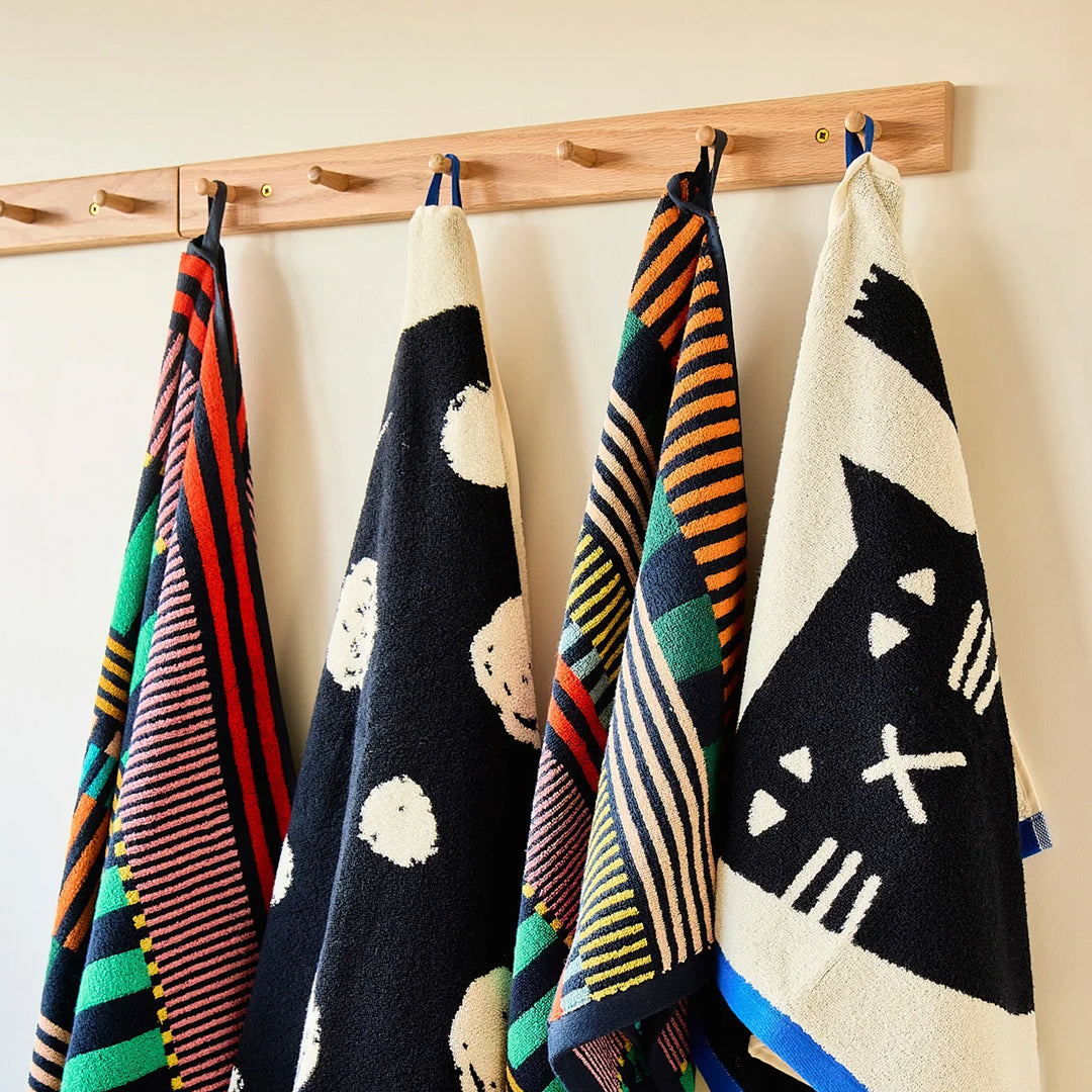 The Donna Wilson Lazy Cat Textile collection brings a playful, design-led twist to everyday bathroom linens. Simple graphic striped cat illustration with a bold blue edge binding.
