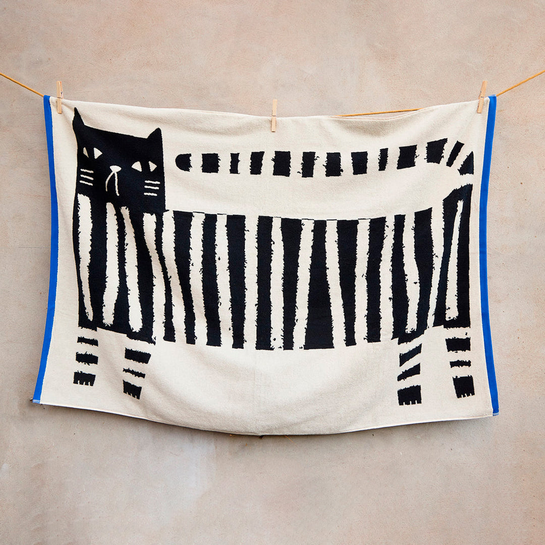 The Donna Wilson Lazy Cat Textile collection brings a playful, design-led twist to everyday bathroom linens. Simple graphic striped cat illustration with a bold blue edge binding.
