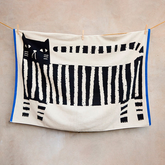 The Donna Wilson Lazy Cat Textile collection brings a playful, design-led twist to everyday bathroom linens. Simple graphic striped cat illustration with a bold blue edge binding.