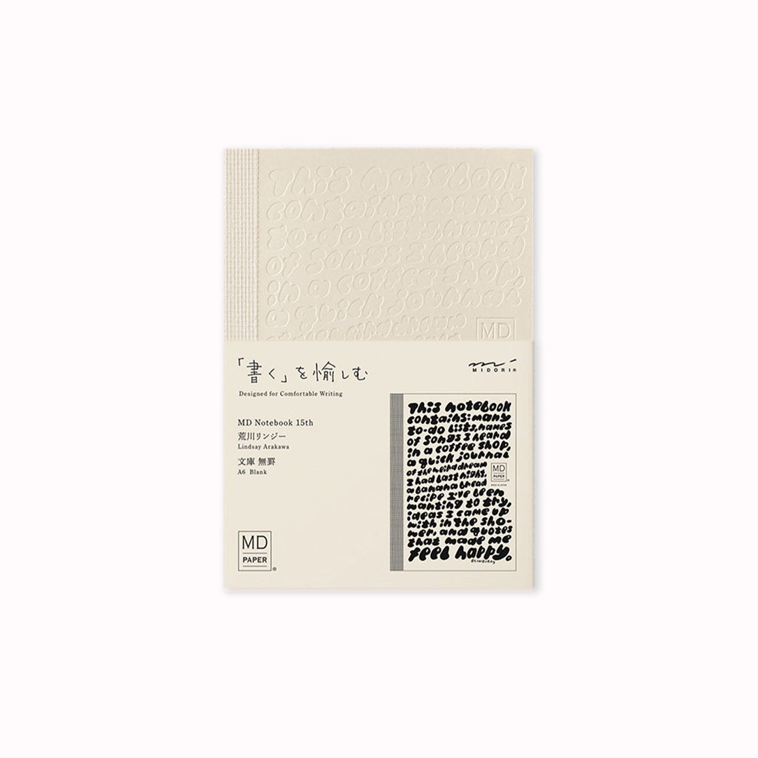 A6 plain paper notebook has an off white cover embossed with some ace artwork by Lindsay Arakawa featuring a hand type design, cutely filling the cover with things that could be written in the notebook. The MD paper logo is also embossed. 