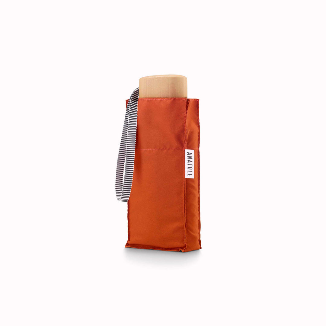 Louis is a bright rust coloured, ultra light-weight folding umbrella by Anatole, Paris.