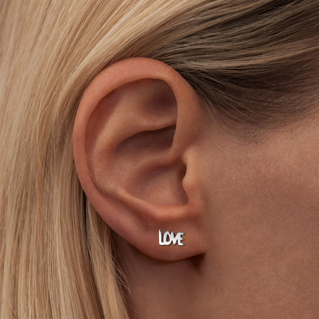 This earring spells out the word "LOVE" in capital letters. As Worn.