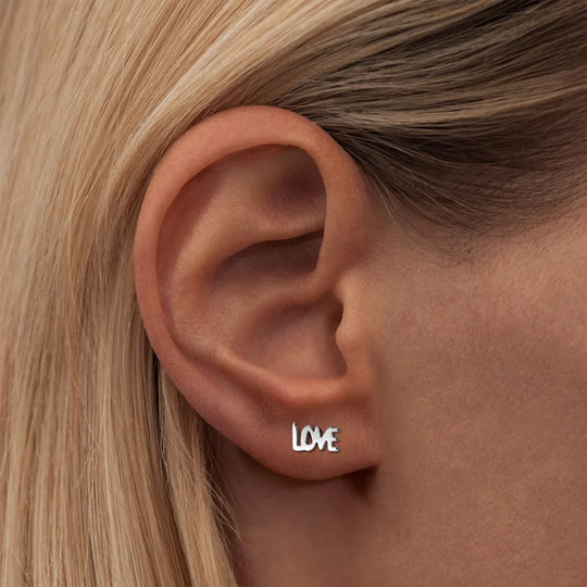 This earring spells out the word "LOVE" in capital letters. As Worn.