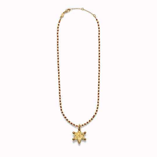 The Anni Lu Lucky Star necklace is a gold Western inspired star shaped gold pendant with glass beaded necklace chain in neutral hazel brown, rust and ecru colours.