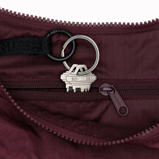 The Medium Crescent Bag in Mahogany from Baggu is a stylish and versatile accessory that can complement any outfit. It is made of durable nylon and features a zippered main compartment, an interior slip pocket, and an adjustable shoulder strap.
