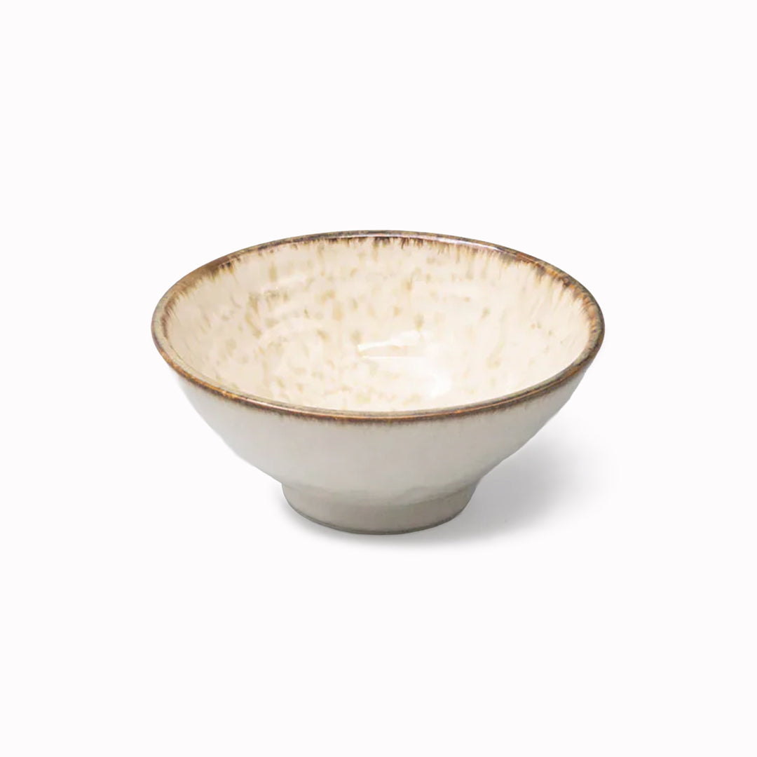 A handcrafted ceramic bowl with a gently flared profile, featuring a creamy glaze with warm, toasted rim accents.