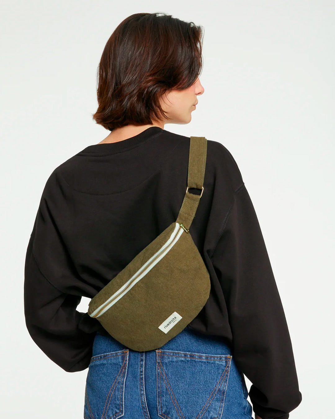 The Military Green Custine Belt Bag is a stylish and practical accessory crafted from upcycled denim. Designed by Rive Droite, a brand known for its commitment to sustainable fashion