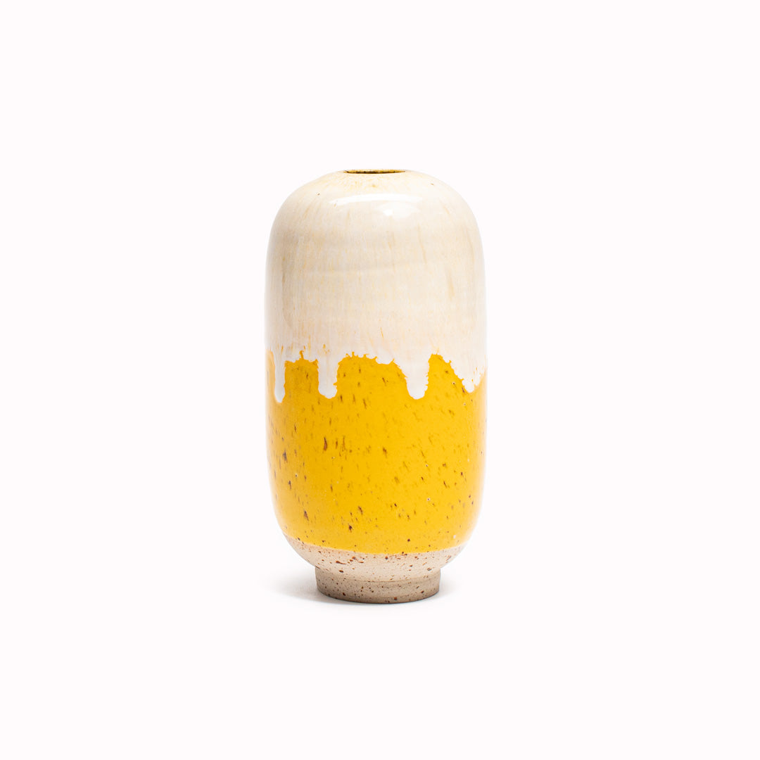 The Milky Lemonade design is hand-thrown in watertight stoneware. Due to the rounded taper at the top of the vase, the glaze melts down the sides of the cylindrical vase mimicking melting ice.