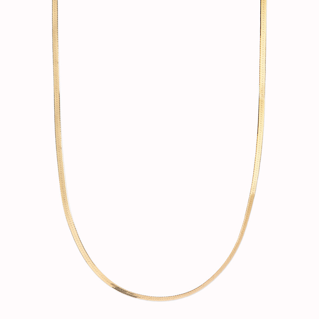 Mio Chain in Gold. Its sinuous, snake-like chain design drapes gracefully around the neck, creating a captivating visual statement. The adjustable length ensures a comfortable fit, allowing you to personalize your style.
