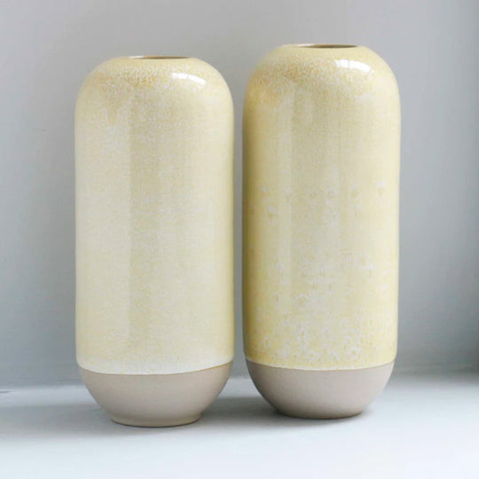 The Cream hued Moneypenny design is hand-thrown in watertight stoneware and due to the rounded taper at the top of the vase, the glaze melts down the sides of the cylindrical vase mimicking melting ice.