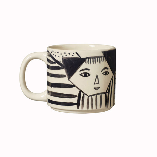 Donna Wilson mug featuring an illustrated black and white face nestled amongst abstract patterns. Every mug is painted by hand, meaning each one is unique.  100% stoneware.