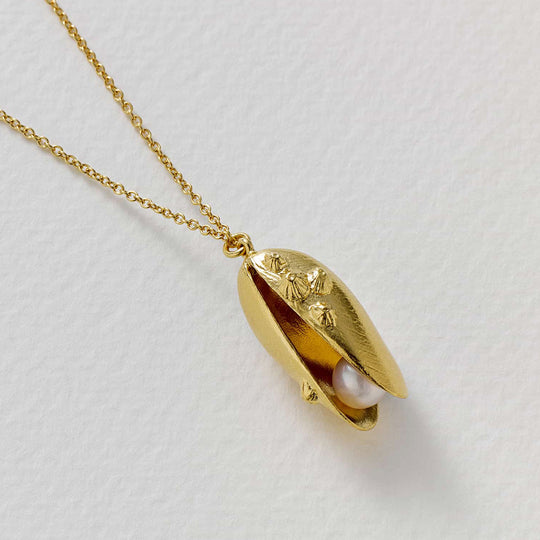 Mussel and Pearl Necklace features an open mussel shell pendant with a freshwater pearl delicately placed within the open shell