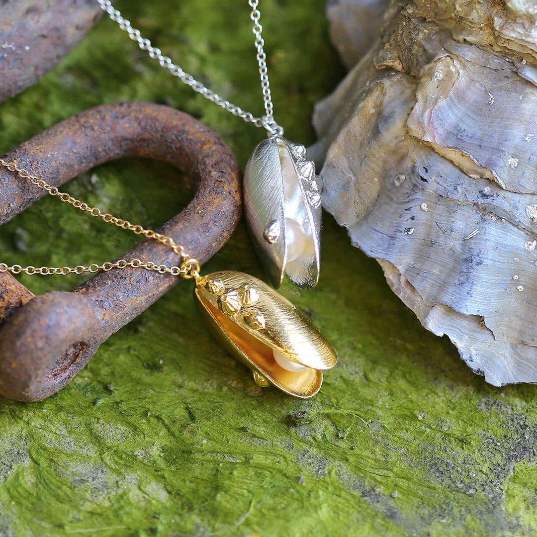 Mussel and Pearl Necklace features an open mussel shell pendant with a freshwater pearl delicately placed within the open shell