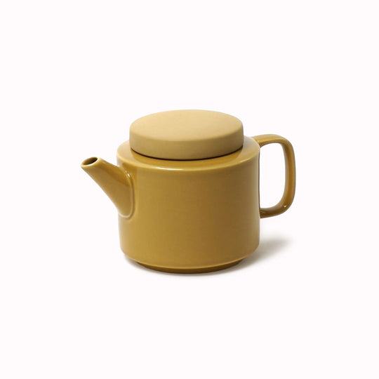 Small stoneware teapot from Dutch company Kinta who produce contemporary ceramics and homeware. The small size teapot is mustard yellow, with a gloss glaze exterior body finish and matt glaze lid. Its design is influenced  by ceramic trends of the 1960s, but with a pleasing modern and neutral colour palette.
