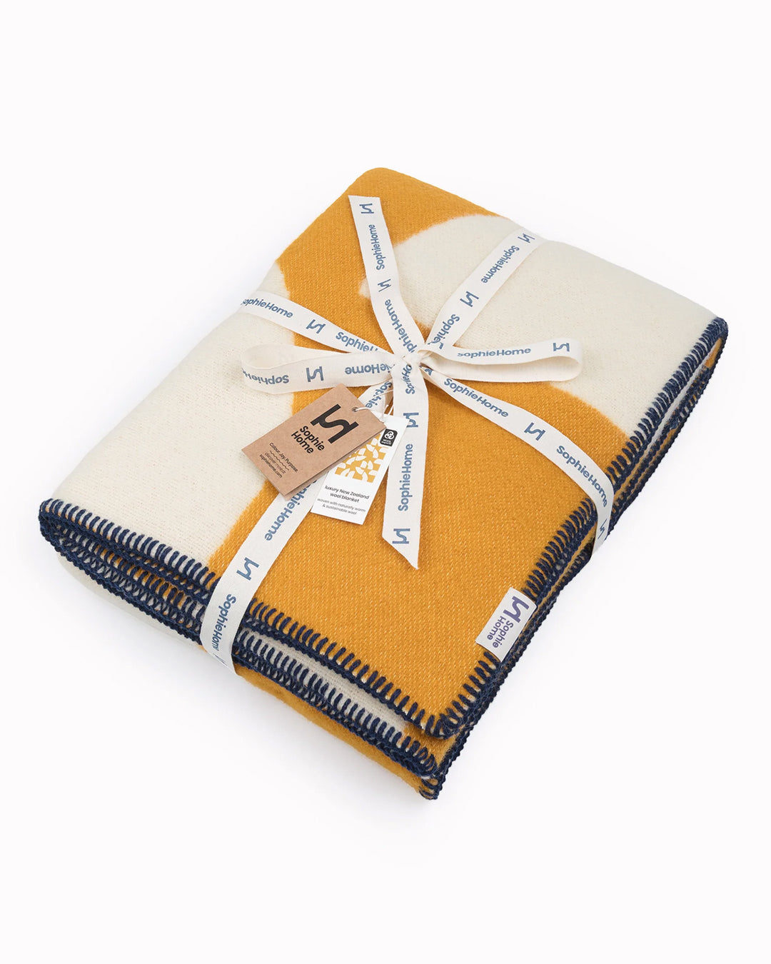 A modern throw in with graphic pattern in mustard and white that sits somewhere between functional and decorative