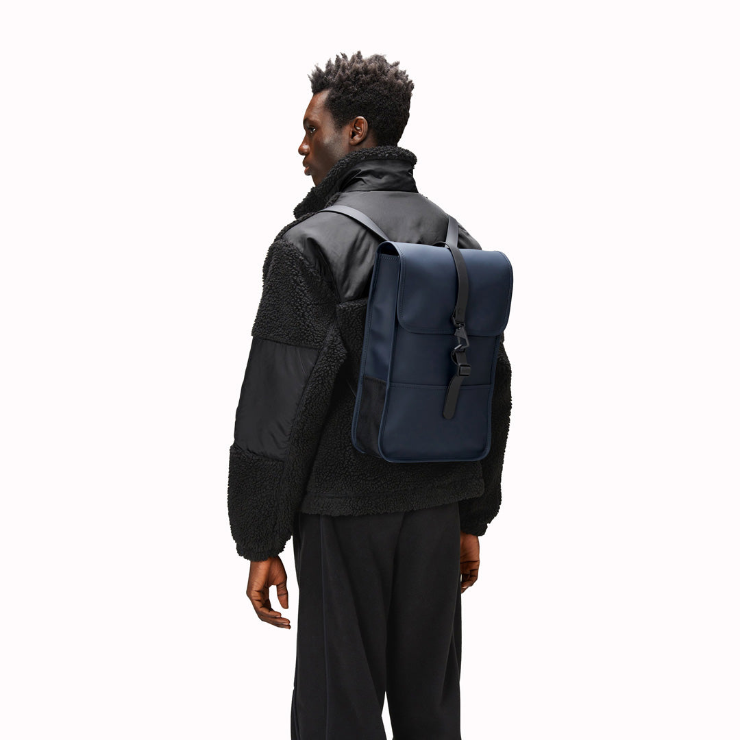 Navy Mini backpack - Made from Rains' signature water-resistant fabric with a matte finish, this minimalistic, modern rucksack is called 'Mini' but is the perfect size for daily use. It has an inside laptop pocket, a spacious main compartment and a hidden phone pocket on the backside.