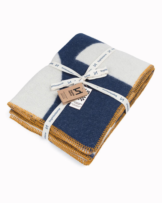 A modern throw in with graphic pattern in navy and ivory that sits somewhere between functional and decorative