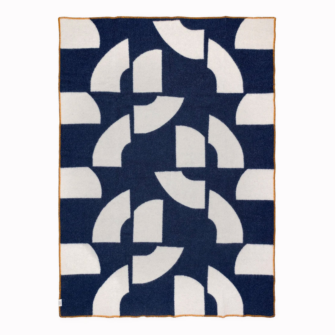 A modern throw in with graphic pattern in navy and ivory that sits somewhere between functional and decorative