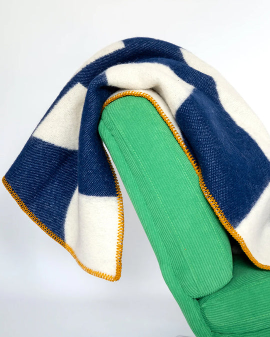 A modern throw in with graphic pattern in navy and ivory that sits somewhere between functional and decorative