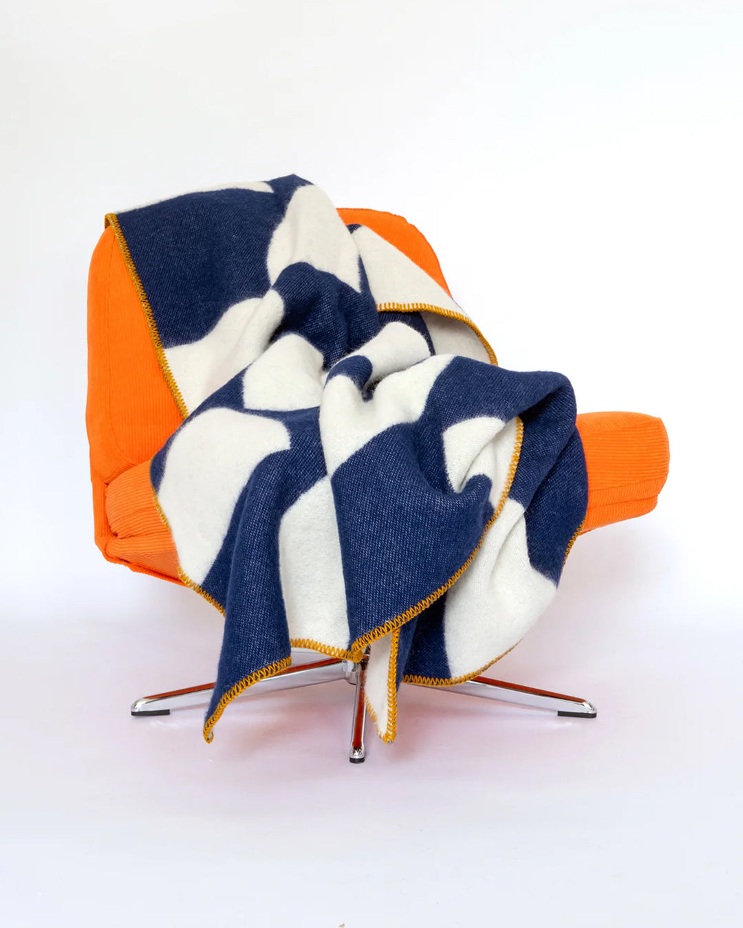A modern throw in with graphic pattern in navy and ivory that sits somewhere between functional and decorative