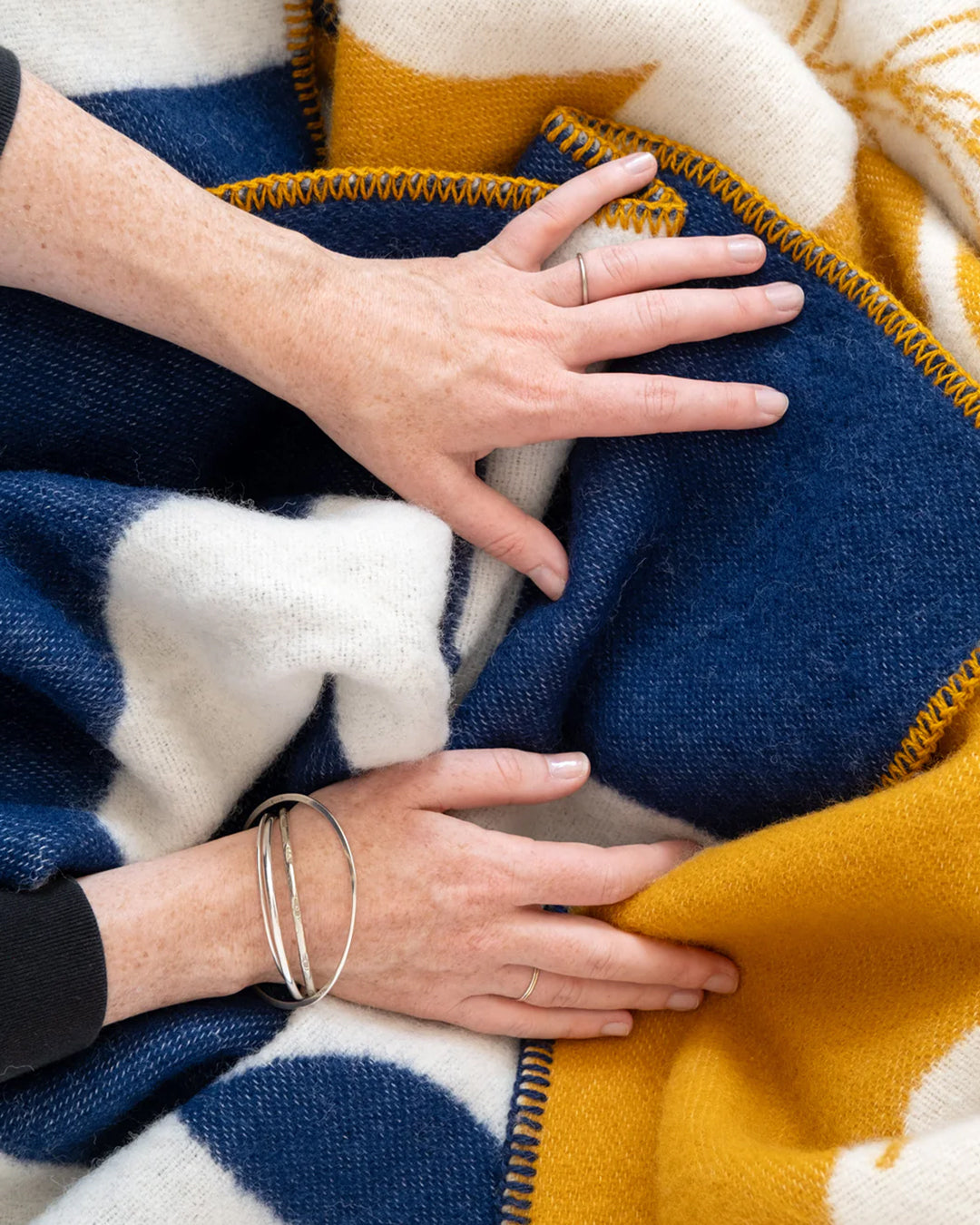 A modern throw in with graphic pattern in navy and ivory that sits somewhere between functional and decorative