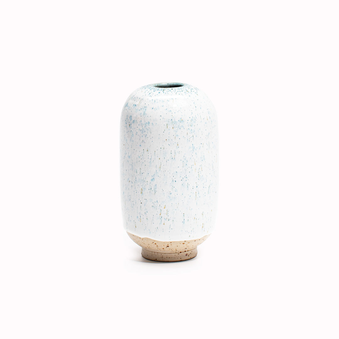 The White over blue Niagra Falls design is hand-thrown in watertight stoneware. Due to the rounded taper at the top of the vase, the glaze melts down the sides of the cylindrical vase mimicking melting ice.