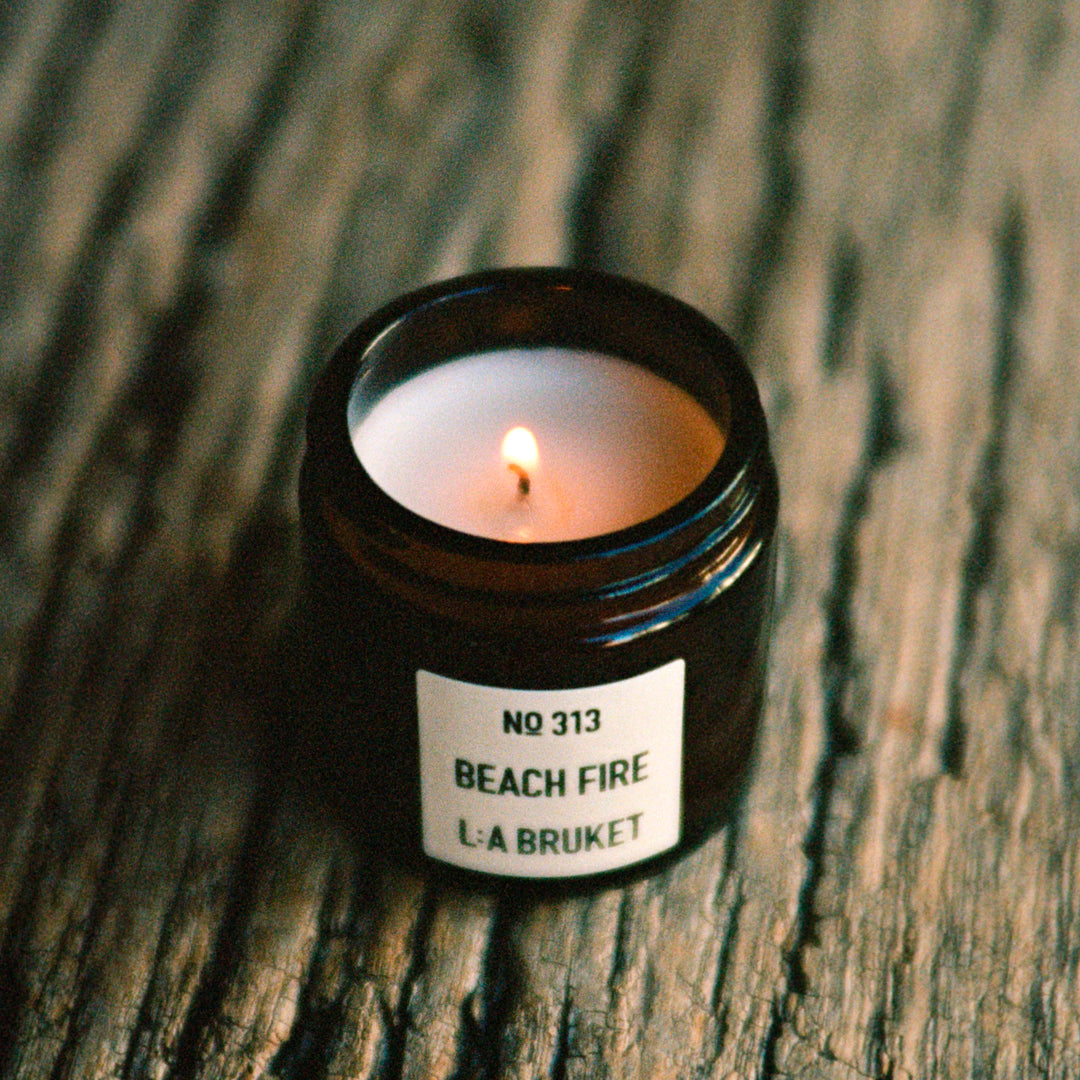 The L:A Bruket 2025 Nightfall Winter Gift Kit contains a soothing duo to wind down the day and prepare for a good night of sleep: 313 Candle Beach Fire 50g and 311 Goodnight Orange Blossom Lip Balm 14g
