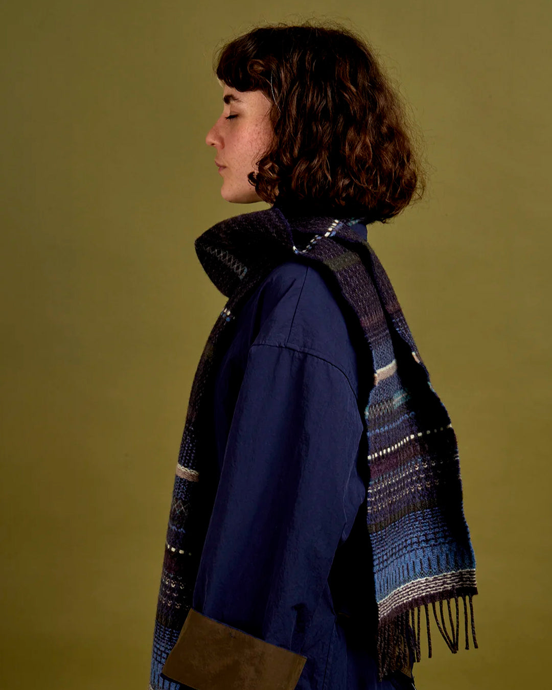 The Noah scarf features a subtle textured weave of background colour offset by intricate detailing at the borders, where delicate floral motifs and patterns mingle with bold cross-hatches, contrasting pinstripes, and graphic bands.&nbsp;