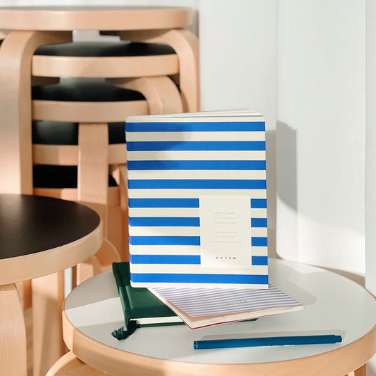 The planner features a minimalist design with a waterproof stripy bright blue and white softcover. The pages are made of high-quality paper that is smooth and acid-free, perfect for writing with any pen or pencil.