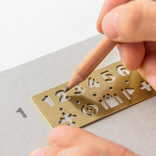Made from solid brass with a tactile weight and finish, this piece works as both a bookmark and an alphabet template you can slot into your notebook or planner.