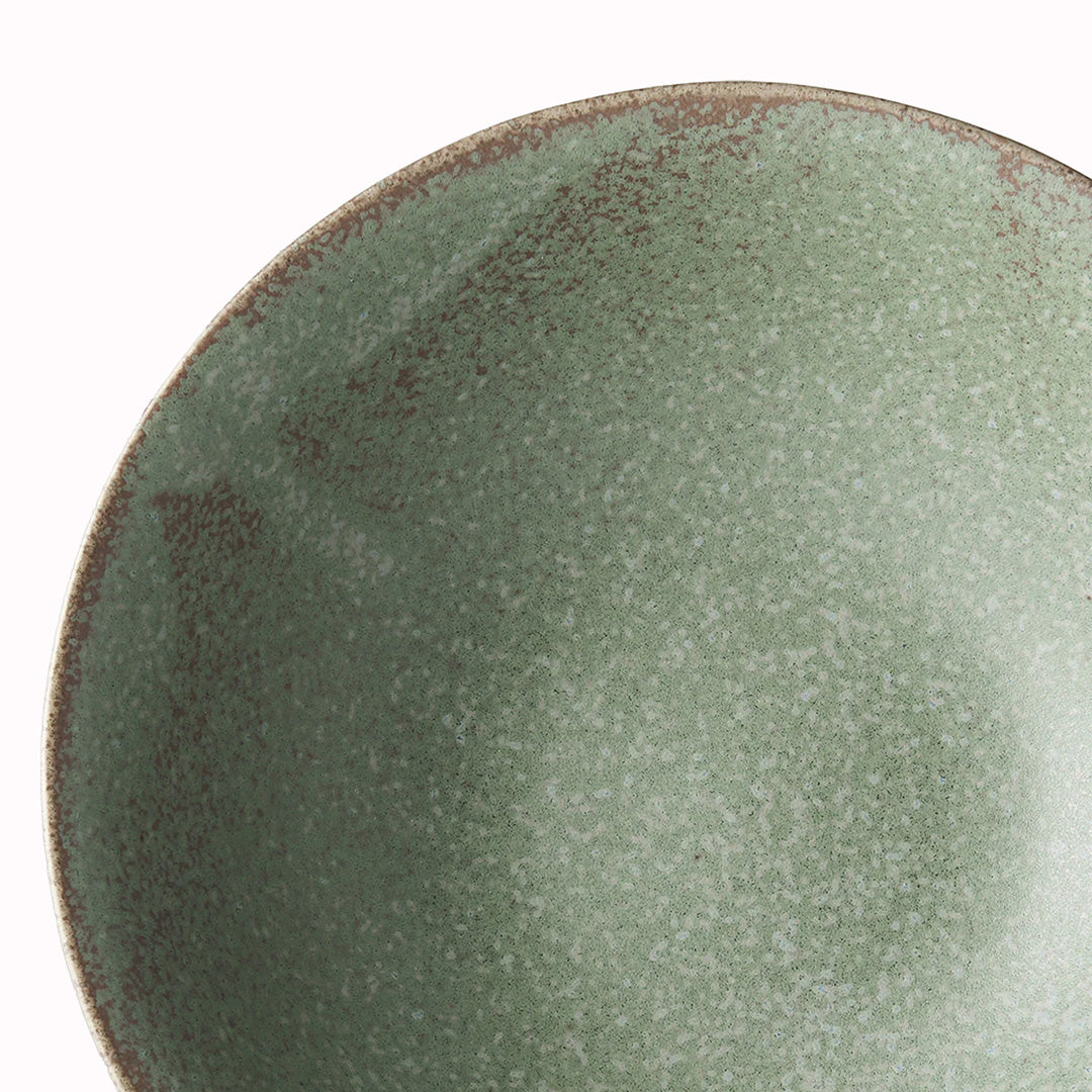 The Green Fade Glaze features a lush, forest green tone with button-flower blue highlights and an edge of light brown. Each piece has a unique dappled pattern determined by its position in the kiln during the firing process.