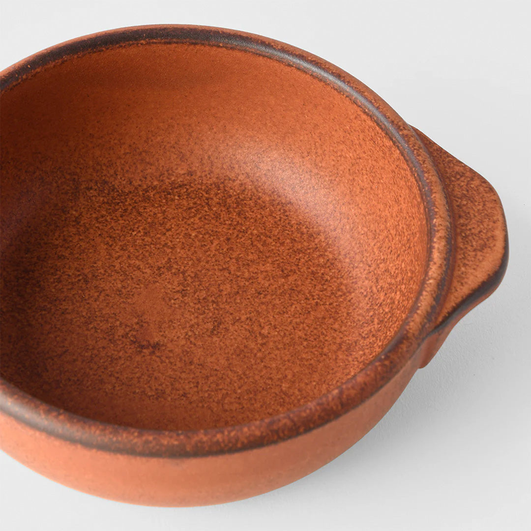 A hand finished Japanese contemporary over proof dish featuring handles and an orange glaze.&nbsp;