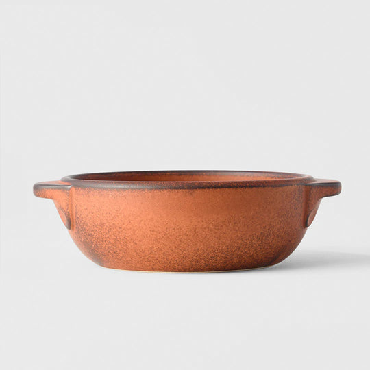 A hand finished Japanese contemporary over proof dish featuring handles and an orange glaze.&nbsp;