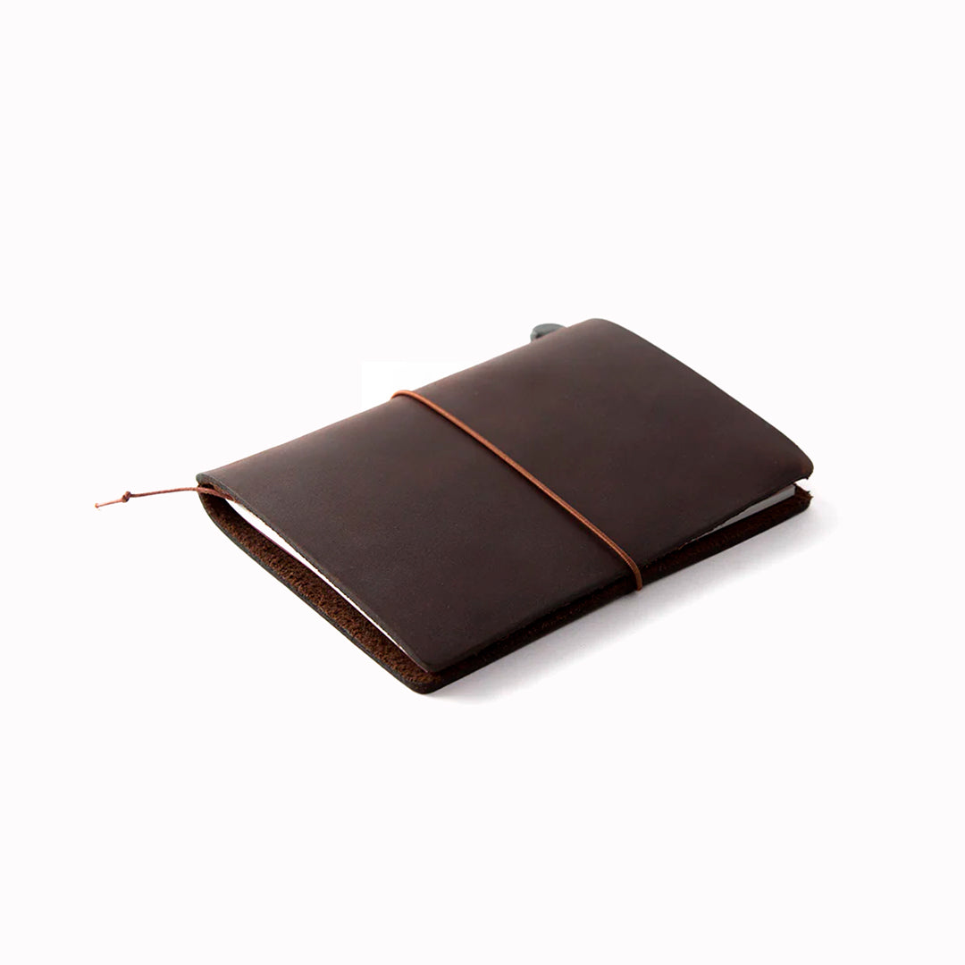 The Traveler's Notebook - Passport Size is a compact, passport‑sized notebook system built for personal organisation, journaling and creative planning. It pairs a handmade cowhide leather cover from Thailand with a blank MD paper insert crafted in Japan