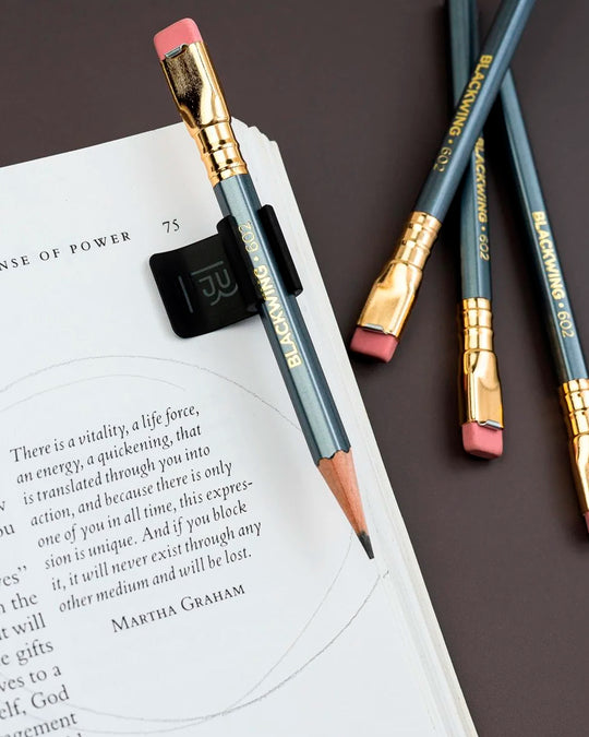 The Blackwing Pencil Holder is a simple metal clip designed to attach securely to the cover of your favourite notebook, giving your pencil a dedicated place to live.