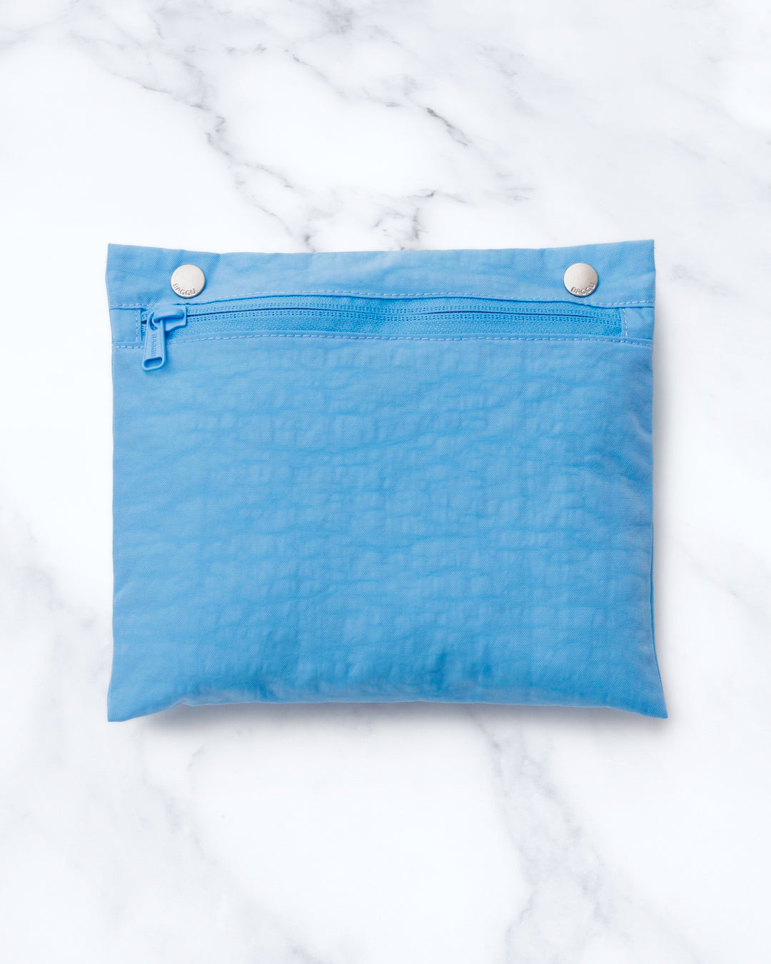 Made from recycled heavyweight nylon, it holds its shape without feeling rigid. The layout is considered: a zipped laptop sleeve sits to one side