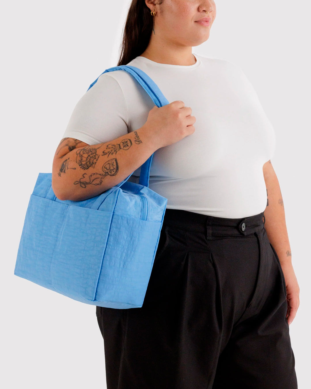 Made from recycled heavyweight nylon, it holds its shape without feeling rigid. The layout is considered: a zipped laptop sleeve sits to one side