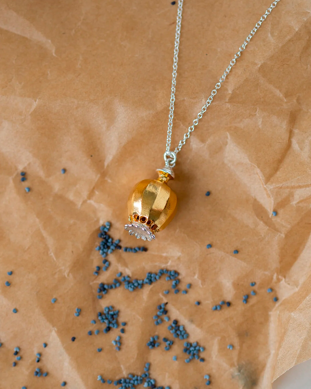 Large Poppy Head Necklace is a stunning sculptural botanical necklace in a mix of silver and gold plated metals. Inside the necklace are tiny silver ball 'shaking seeds' for a subtle sound feature.&nbsp;