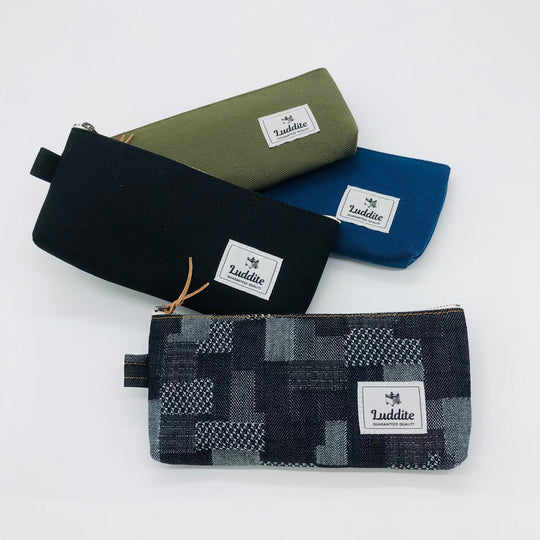 Flat pouch style pen and pencil case by Japanese stationery brand Luddite. the durable and tactile pencil case features a zipper along the length of the pencil case allows easy access to the items inside.