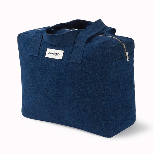 Raw Denim Célestins bag from Parisian brand Rive Droite is a chic canvas overnight travel bag with enough room for night away (or 2 if you pack light!) Viewed from an angle