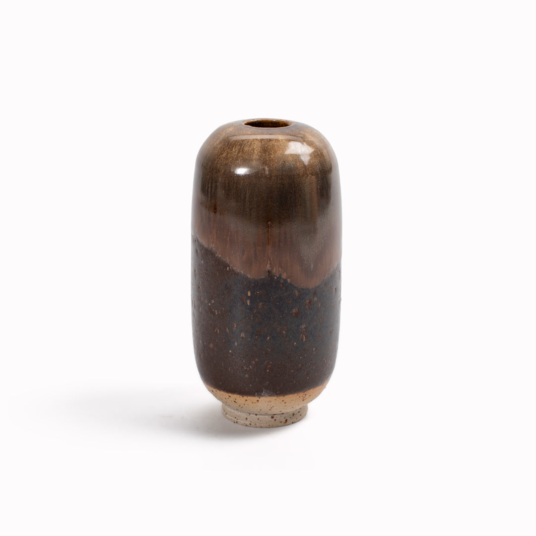 The glossy brown 'Root Beer Float' design is hand-thrown in watertight stoneware and due to the rounded taper at the top of the vase, the glaze melts down the sides of the cylindrical vase mimicking melting ice.