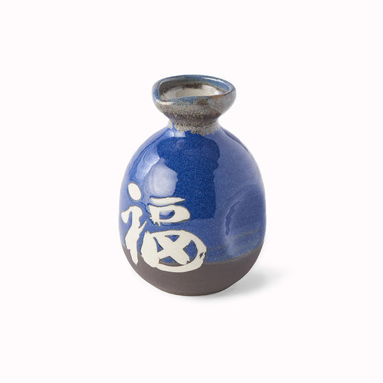 A decorative Japanese Sake jug with decorative kanji (meaning 'Japan') in a dark blue glaze with white Kanji.