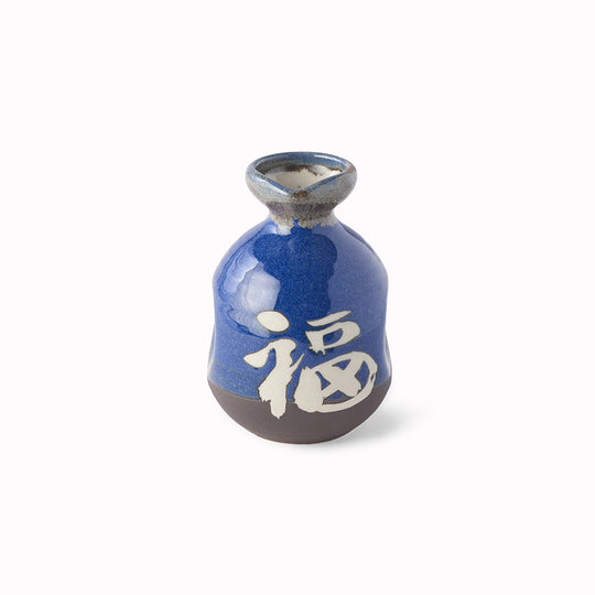 A decorative Japanese Sake jug with decorative kanji (meaning 'Japan') in a dark blue glaze with white Kanji.
